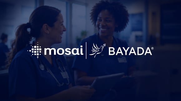 Two female nurses smiling and talking to each other.