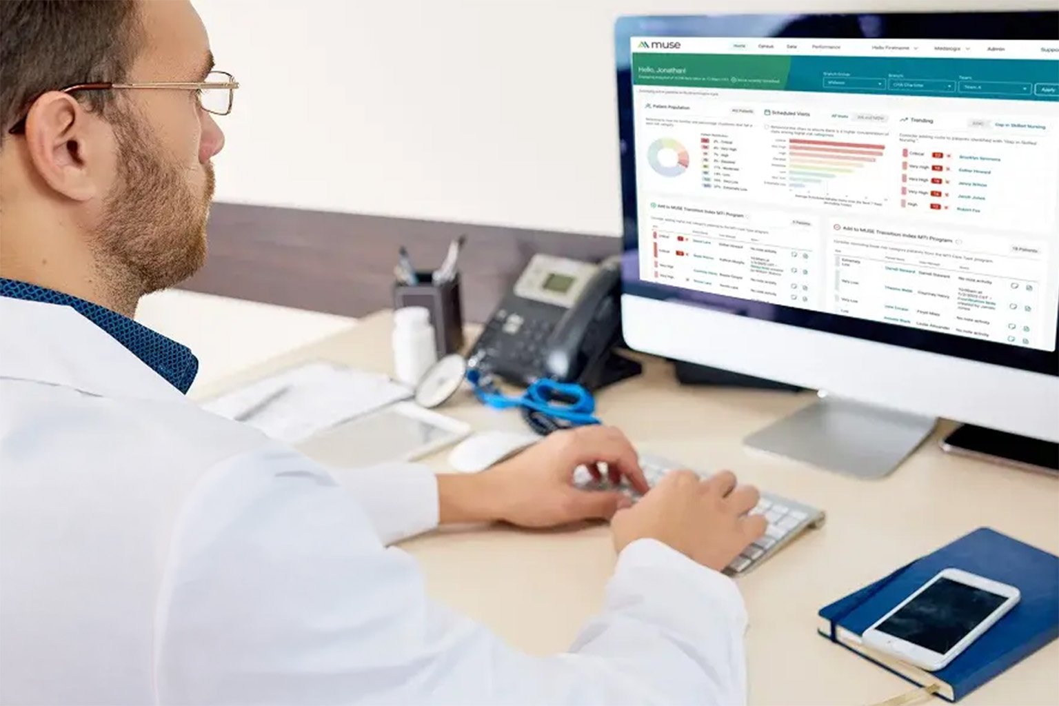 Doctor typing on a computer at a desk.