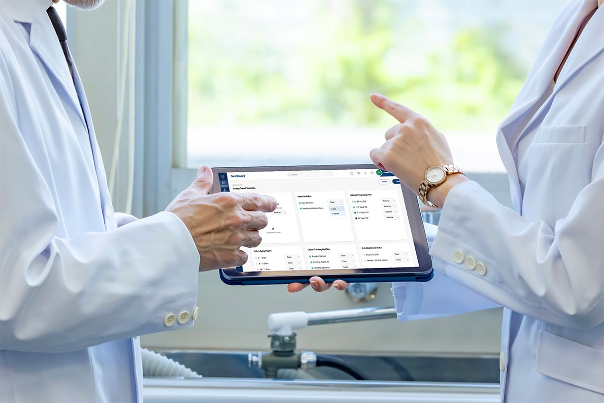 Two doctors holding tablet between them.