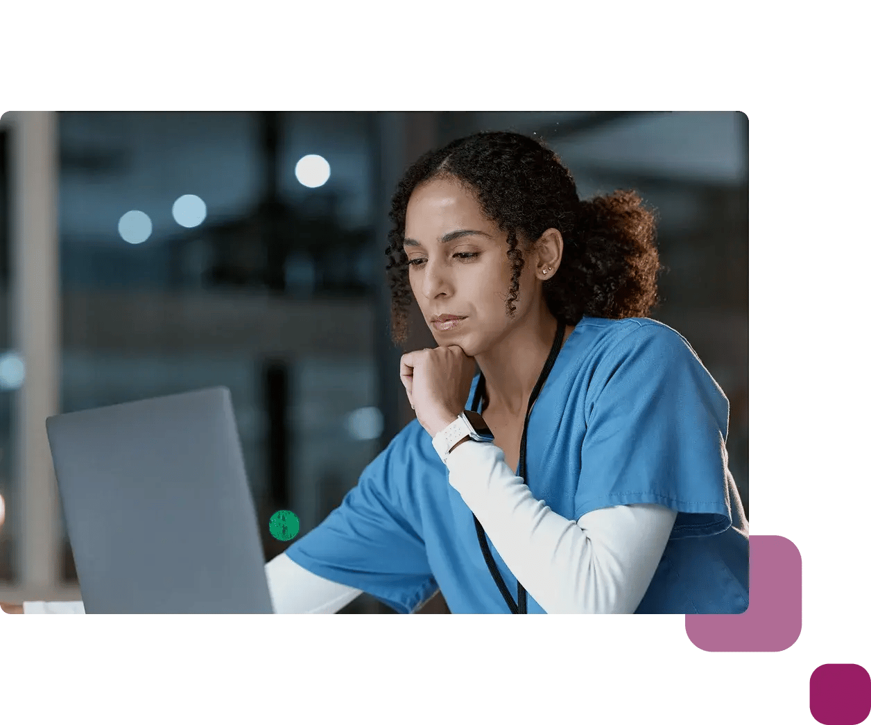 serious lady on laptop wearing scrubs