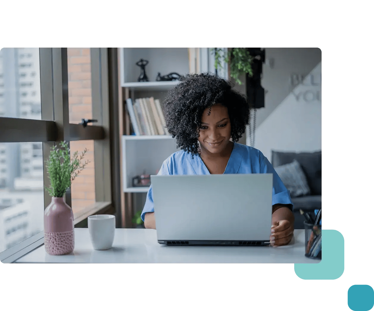 lady in scrubs on laptop