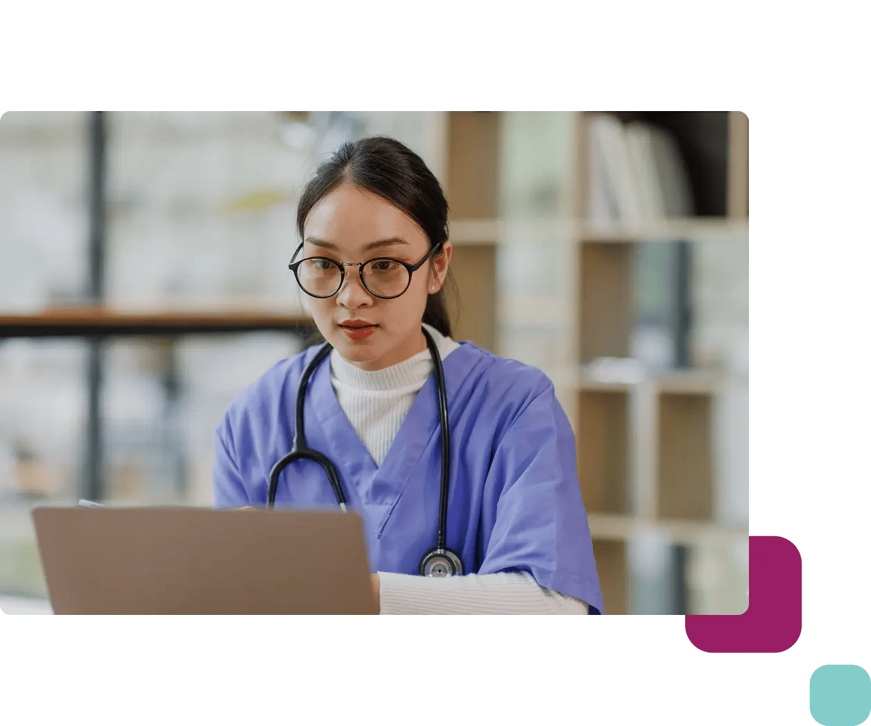 Female nurse with glasses using laptop