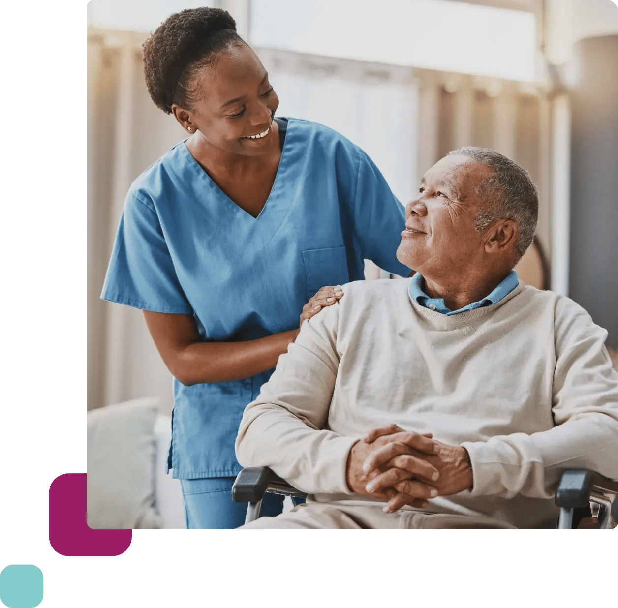 Nurse smiling at elderly man in wheelchair